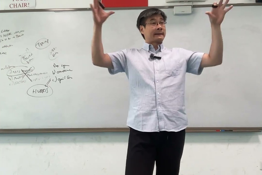 Jiang Xueqin teaching at a whiteboard, arms raised, course notes behind him